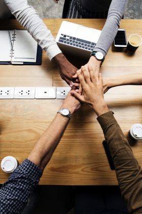 Team of business people stacking hands Team of business people stacking hands